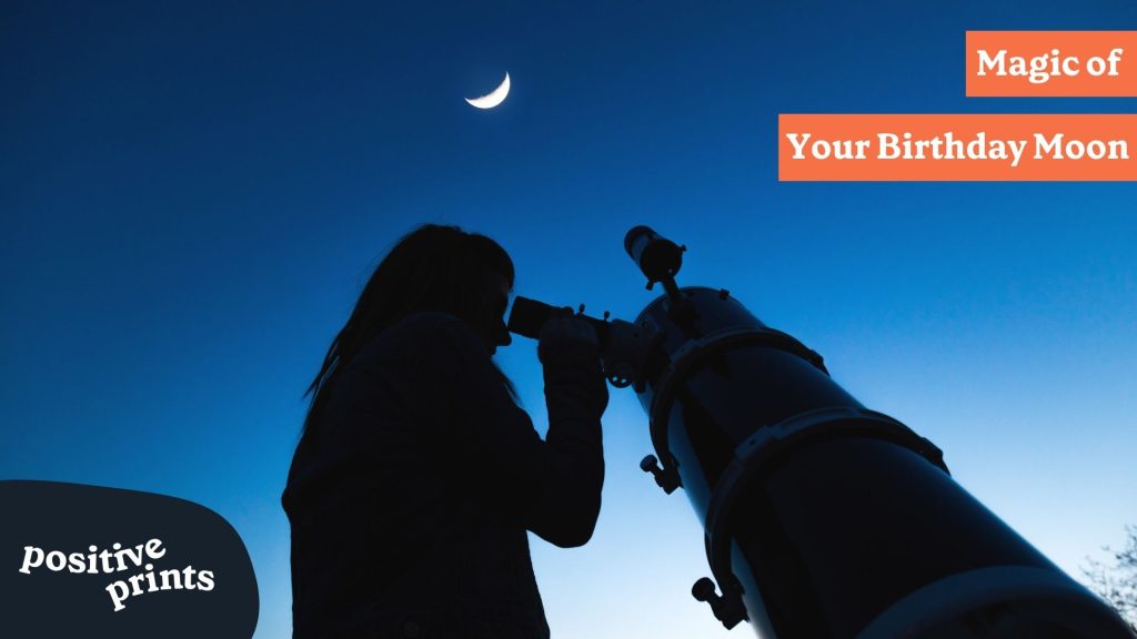 Person looking through telescope at crescent moon in deep blue night sky with 'Magic of Your Birthday Moon' title and Positive Prints logo